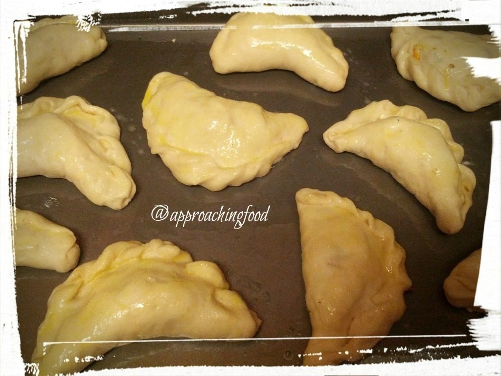 Egg-brushed empanadillas ready for oven.