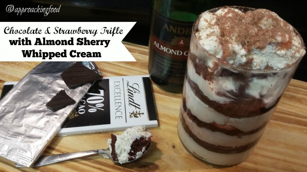 Chocolate & Strawberry Trifle with Almond Sherry Whipped Cream, displayed with a chocolate bar and a bottle of Almond Sherry.